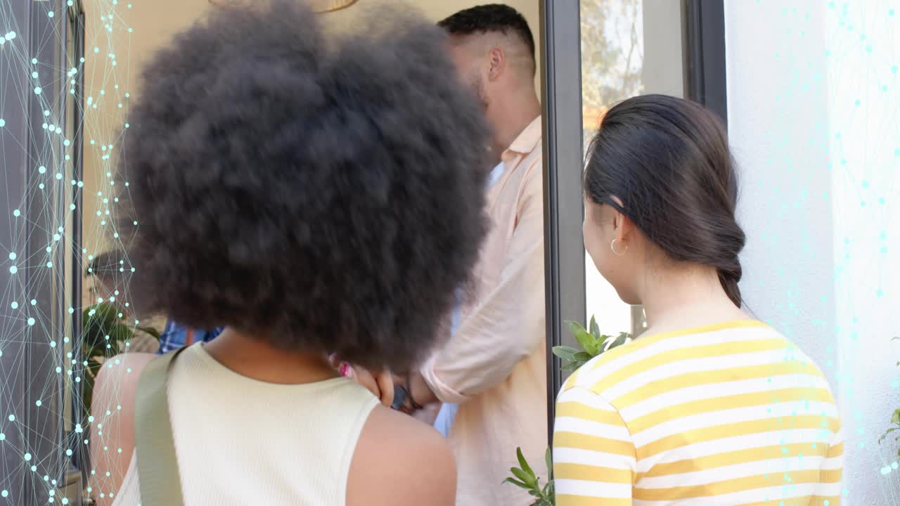 Host opening front door, greeting arriving guests, shaking hands and hugging, guiding into home