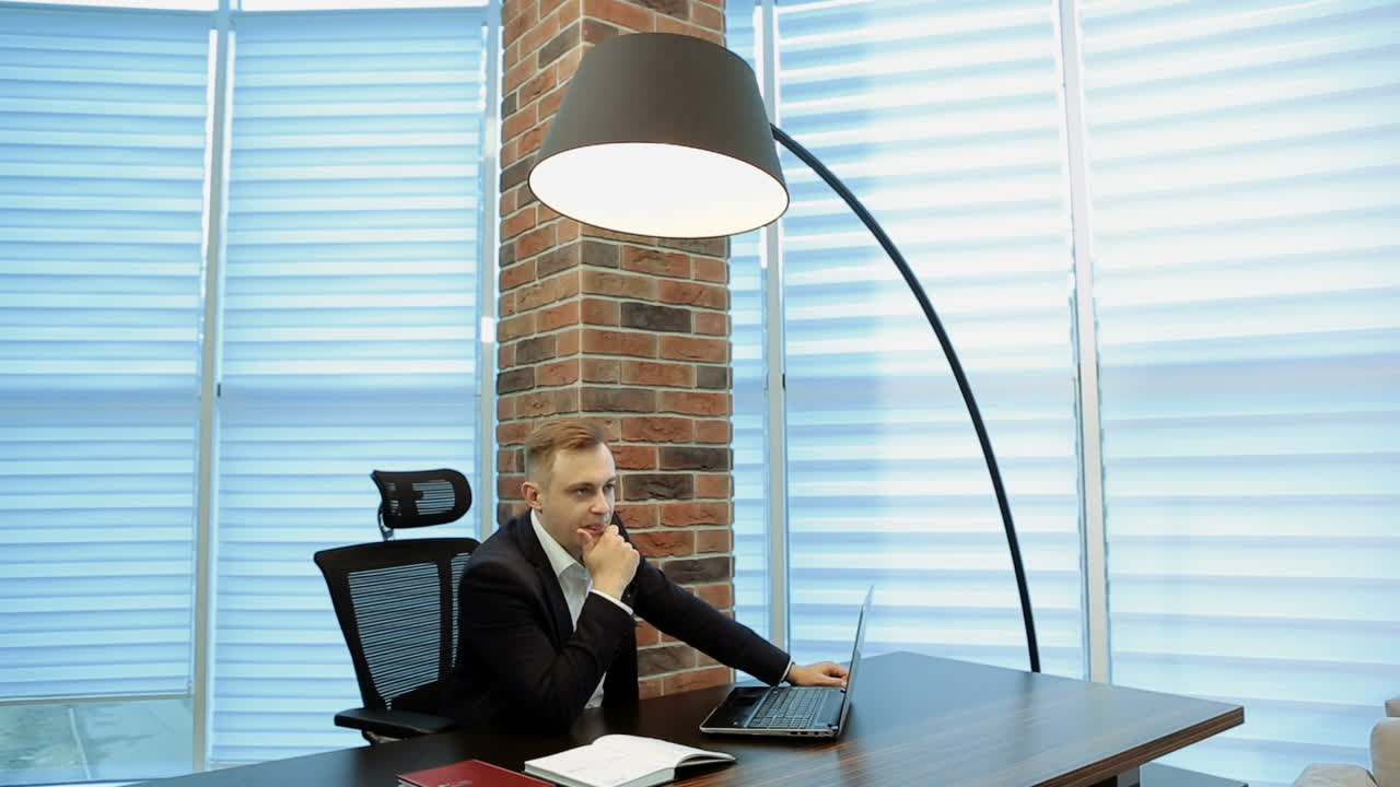 Uomo d'affari sotto stress al lavoro. Un professionista che lavora al computer portatile è solo con i suoi pensieri.