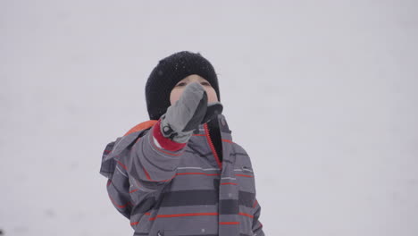 un niño pequeño mira a su alrededor con asombro por la nieve que cae