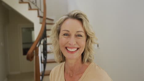 Portrait-of-smiling-caucasian-woman-looking-at-camera-at-home