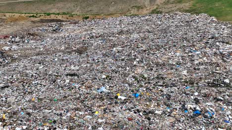 aerial drone flyover of landfill with filled trash