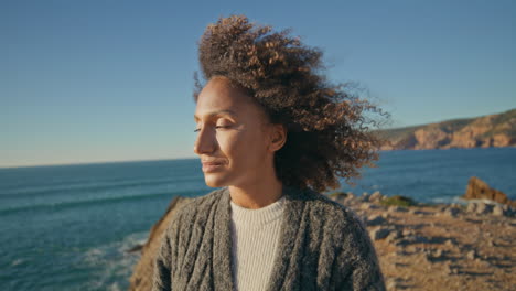 romantic woman looking sea on sunny day closeup. relaxed windy hair girl resting
