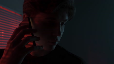 young man in the dark with a phone