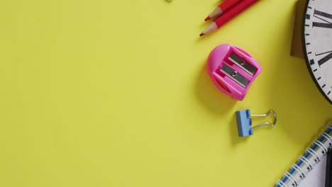 video van schoolbenodigdheden en notitieboeken, paperclips, pennen op gele achtergrond