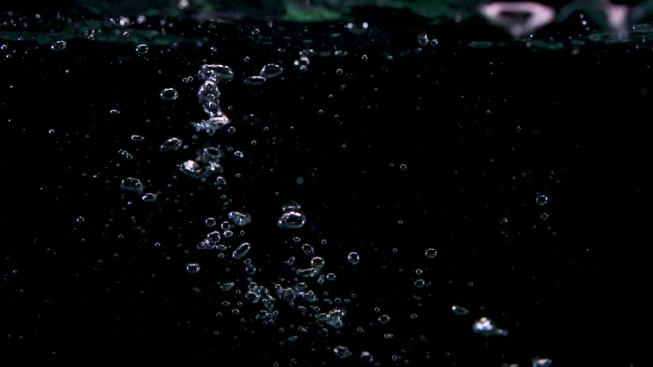 jugando fichas verdes en agua con burbujas en cámara lenta en burbujas