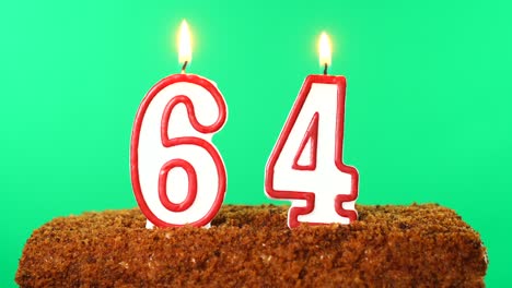 cake with the number 64 lighted candle. chroma key. green screen. isolated