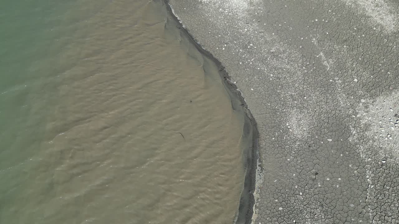 грязная вода течет рядом с полосой земли