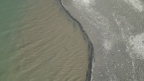 muddy water flowing near a strip of land