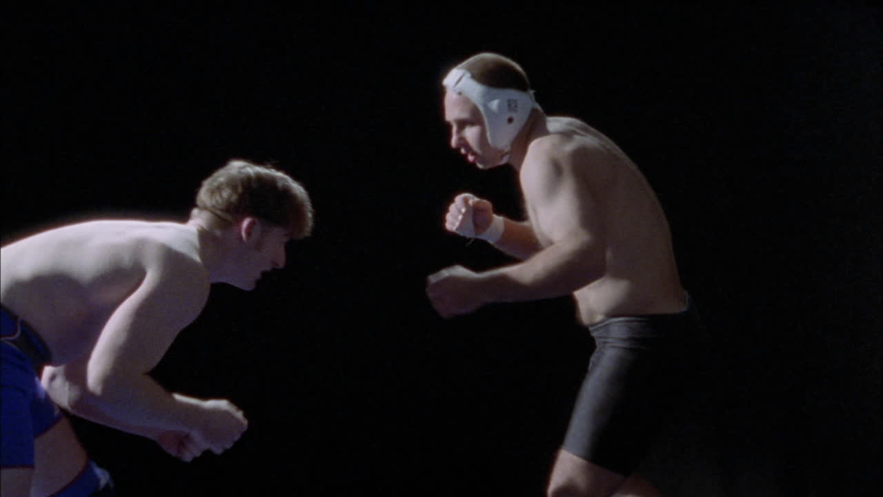 레슬링 중 한 남자가 엉덩이 던지기에서 쓰러집니다.