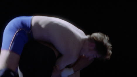 one man is taken down from a hip throw while wrestling