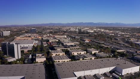 wide aerial rising shot of the 110 freeway with downtown los angeles in the far distance