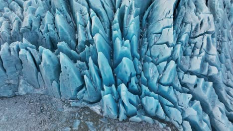 aerial view over textured ice formations of a glacier in iceland, at dusk