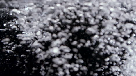 bubbles rising to surface in slow motion water with clear black background