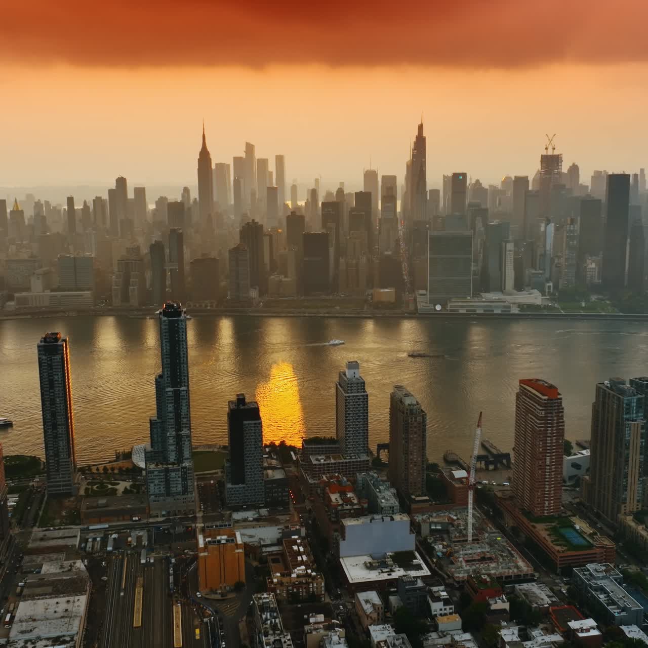Incredibile paesaggio di nuvole arancioni sopra il fiume Hudson. Maestosi grattacieli di New York visti dall'alto al tramonto