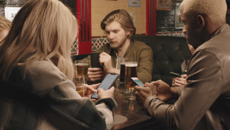 bored friends using smartphones during dinner