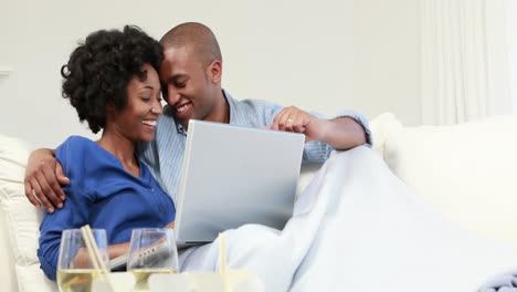 Attractive-couple-using-laptop-on-the-couch