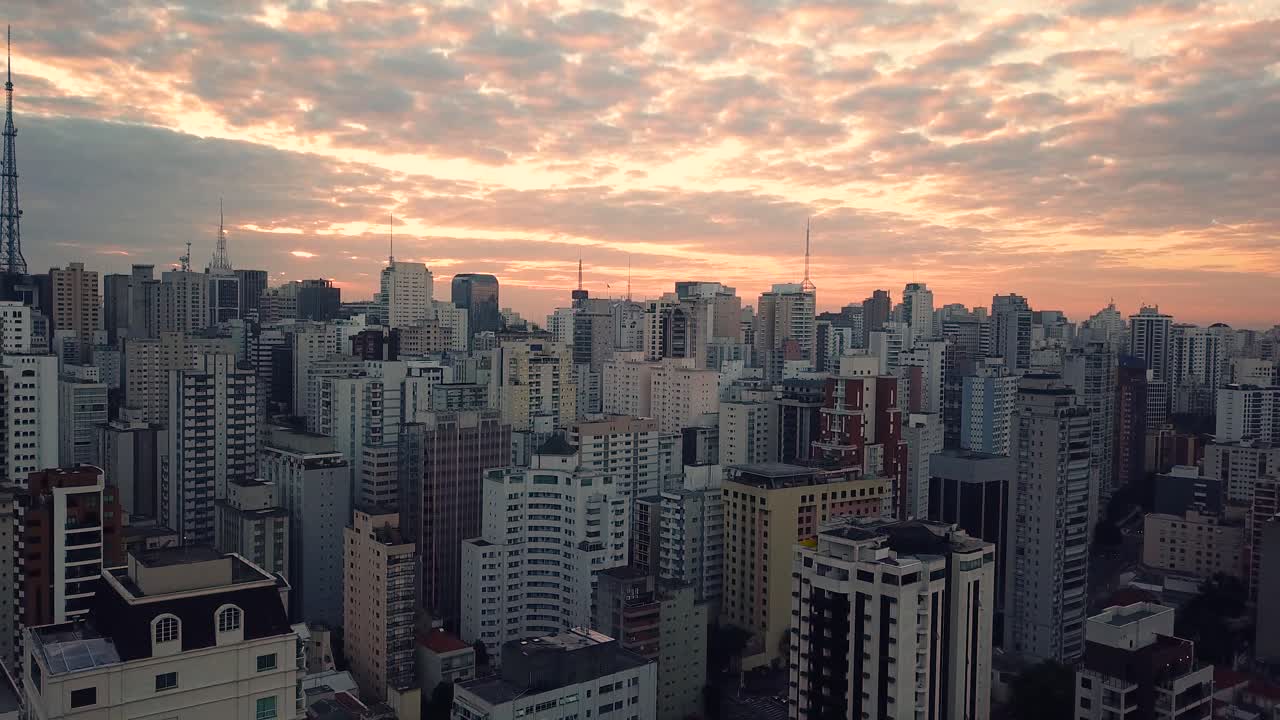 impresionante toma aérea 4k revelando el centro de la ciudad de sao paulo al amanecer, hermoso cielo naranja