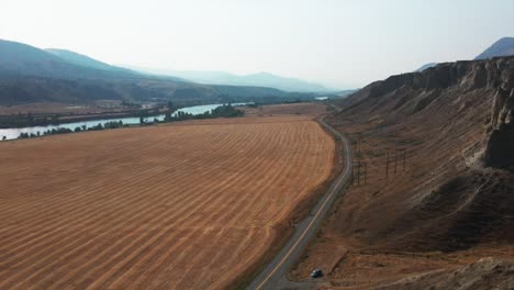 Beautiful-aerial-view-of-road-between-a-hill-and-fields