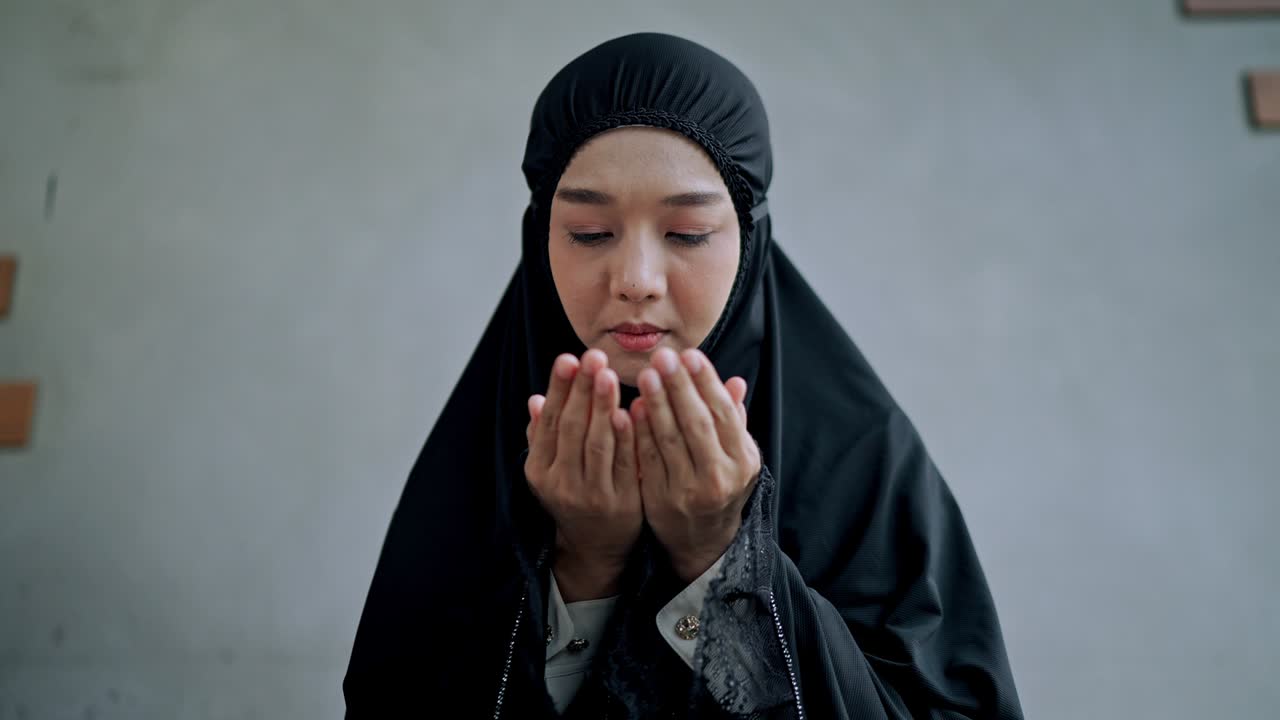 집에서 기도하는 아시아 젊은 무슬림 여성