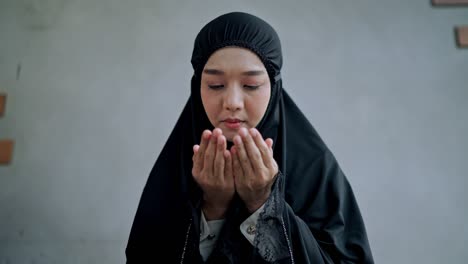 asian young muslim woman praying at home