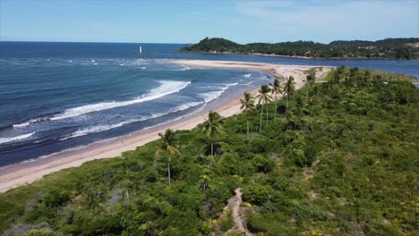 Tiro-De-Drone-Costero-Volando-Más-Allá-De-Palmeras-Con-Faro-En-La-Distancia