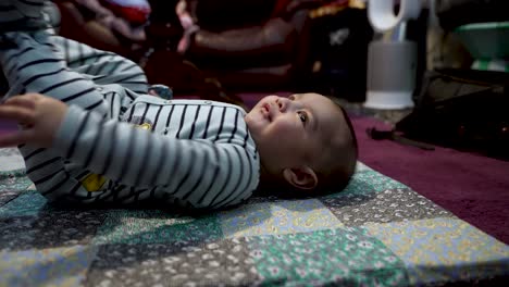 Adorable-Bebé-Indio-De-4-Meses-Tirado-En-Una-Alfombra-En-El-Suelo,-Retorciéndose-Y-Gesticulando