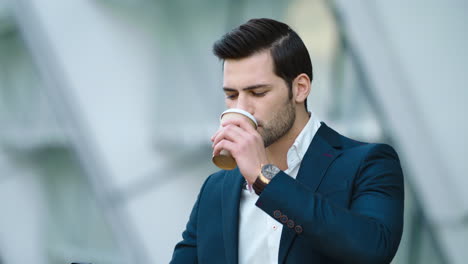 Portrait-man-standing-with-coffee-and-phone.-Man-drinking-take-away-coffee