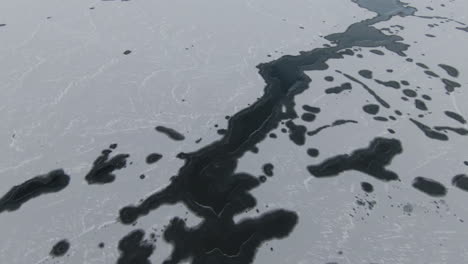 dolly forward, above frozen lake towards snowy mountains, at sunrise