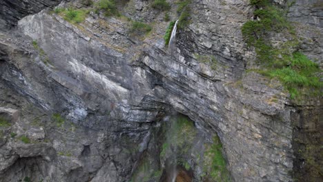 ladera rocosa salpicada por agua que cae desde el pico alto de la montaña en los alpes albaneses