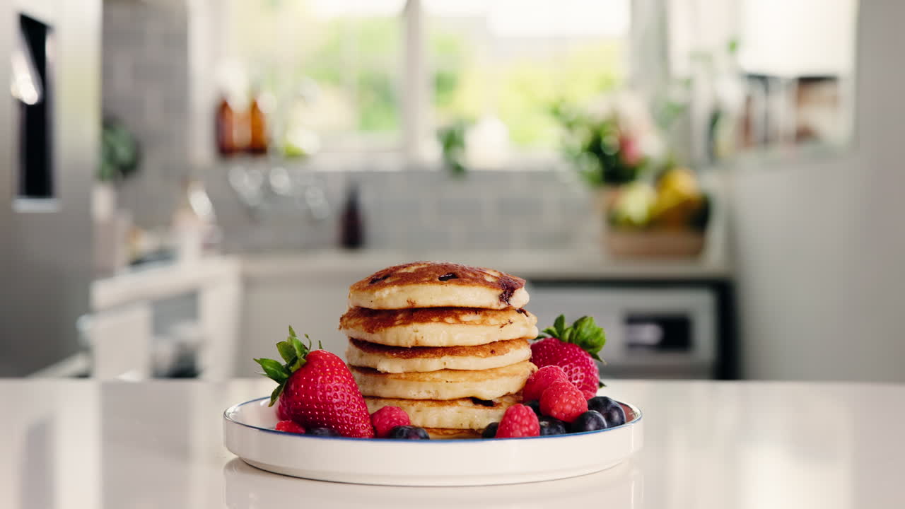 Pila di pancake freschi con frutti di bosco sul bancone della cucina