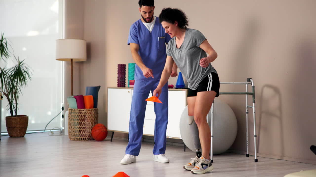 un fisioterapeuta anima a un paciente con una pierna protésica durante una sesión de rehabilitación
