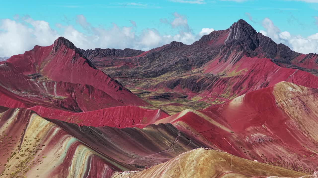 Rainbow Mountain Vinicunca Montaña de Siete Colores Peru Perú aerial drone Peruvian Andes seven colored mountains melted glacier Winikunka Vilcanota Cusco Region morning blue sky clouds zoom out