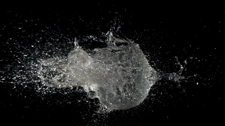 Palloncino d'acqua che scoppia al rallentatore su sfondo nero