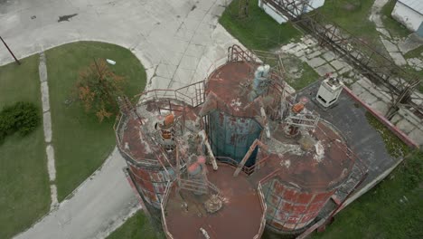 aerial jib up shot of rusty industrial containers in factory complex