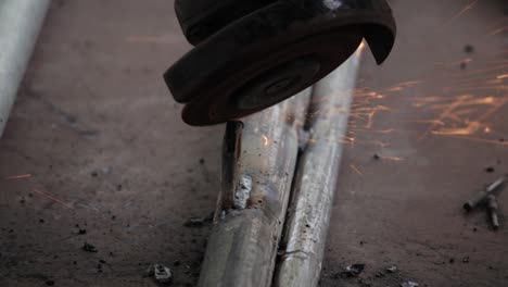 elimine el exceso de metal de soldadura en las tuberías de hierro y obtenga un acabado suave de la soldadura, utilizando una amoladora manual eléctrica del clip de cámara lenta al aire libre de manitas