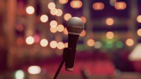 close-up of a microphone on a stage with blurred lights in the background