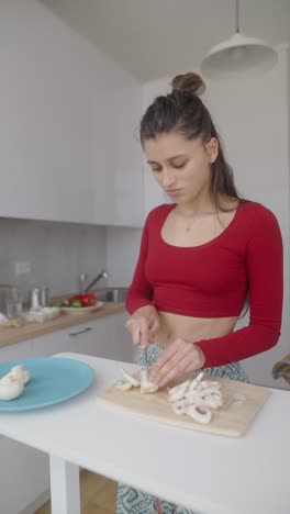 woman cooking mushrooms in kitchen