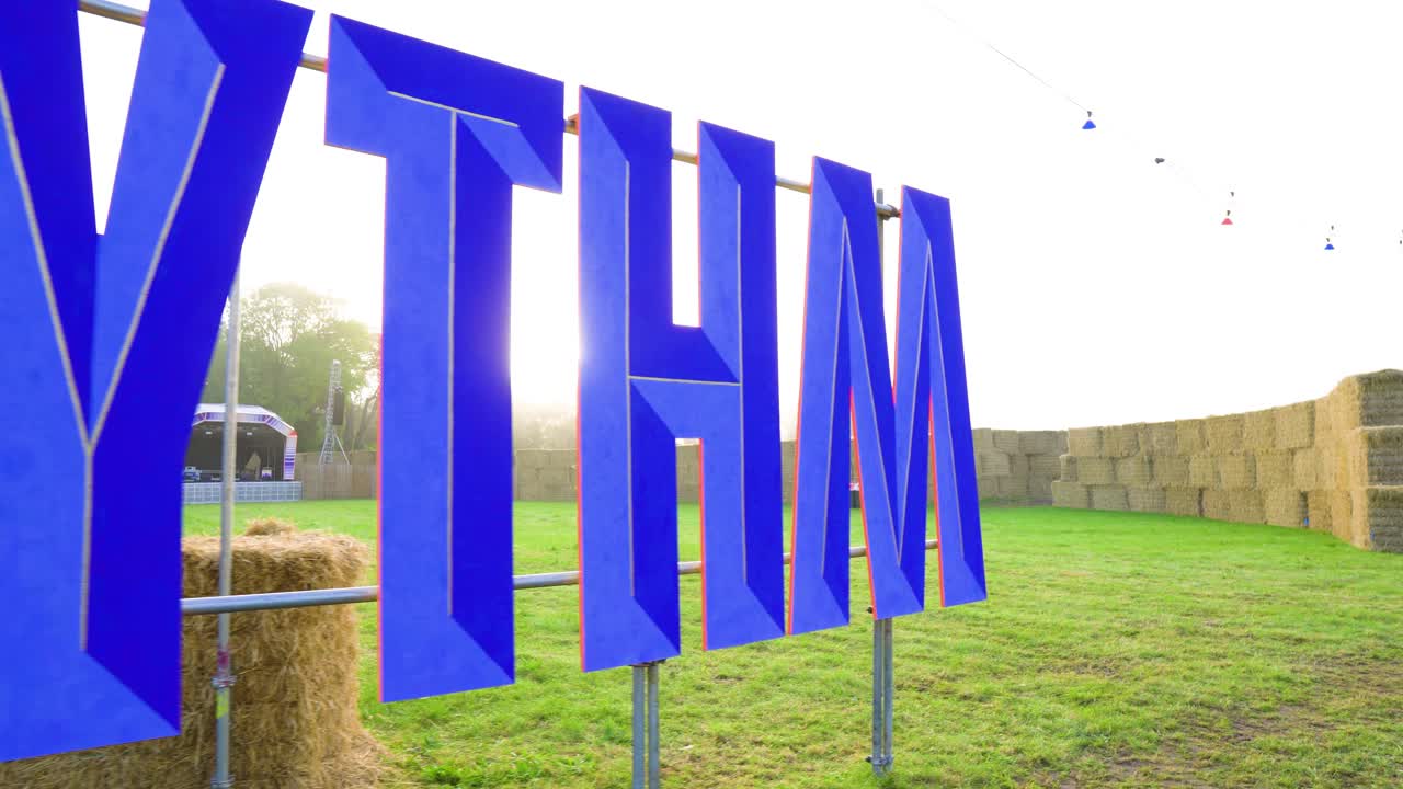 메탈 울타리에 장착 된 거대한 표지판은 축제 아침 해가 뜨는 공간 전체의 다양한 장소에서 반 원 모양으로  ⁇ 어져 있습니다.