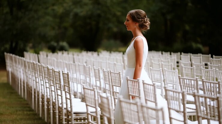 Bride Caucasian Standing Among Chairs, Waiting Before Outdoor Ceremony In Garden Venue, White Gown With Updo,