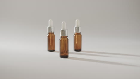 close up of three glass bottles with pumps with copy space on white background