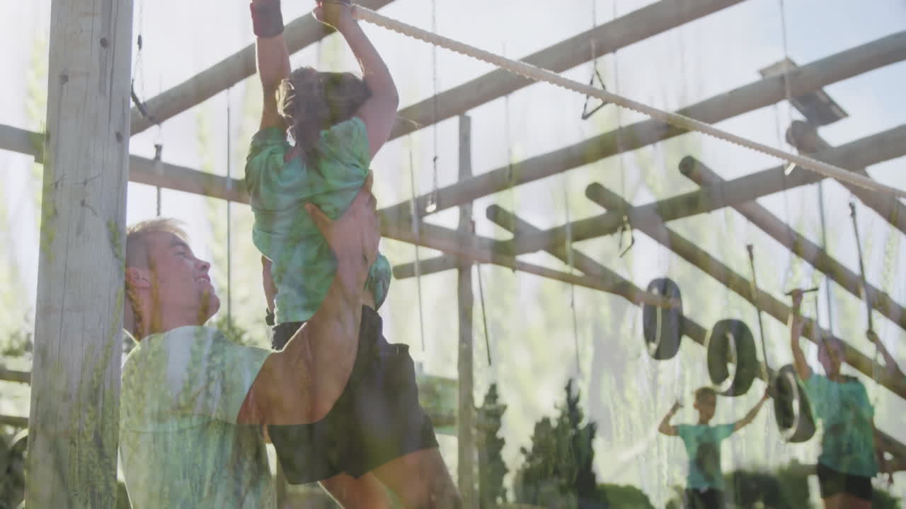 Helping child on obstacle course, man guiding in outdoor setting with greenery