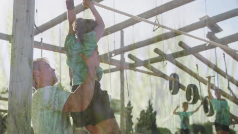 helping child on obstacle course, man guiding in outdoor setting with greenery