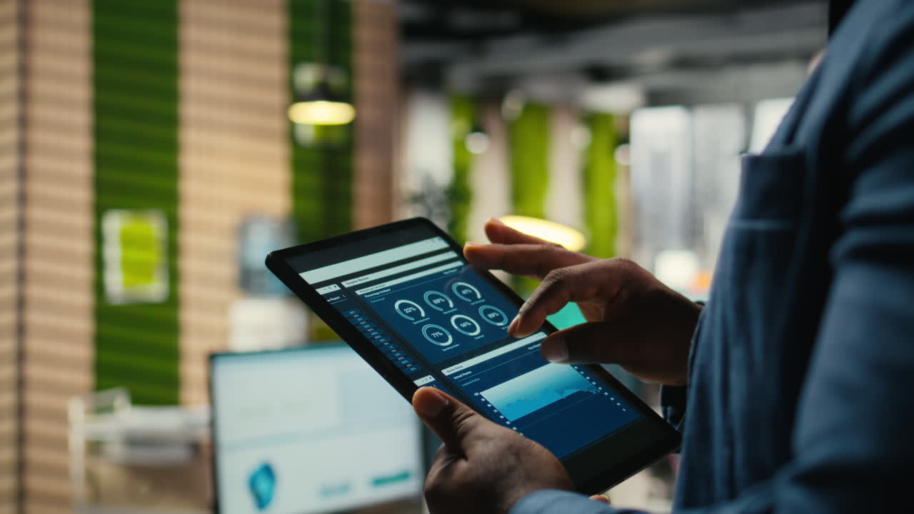 Vertical Video Close up of black employee engages in charts analysis session on tablet