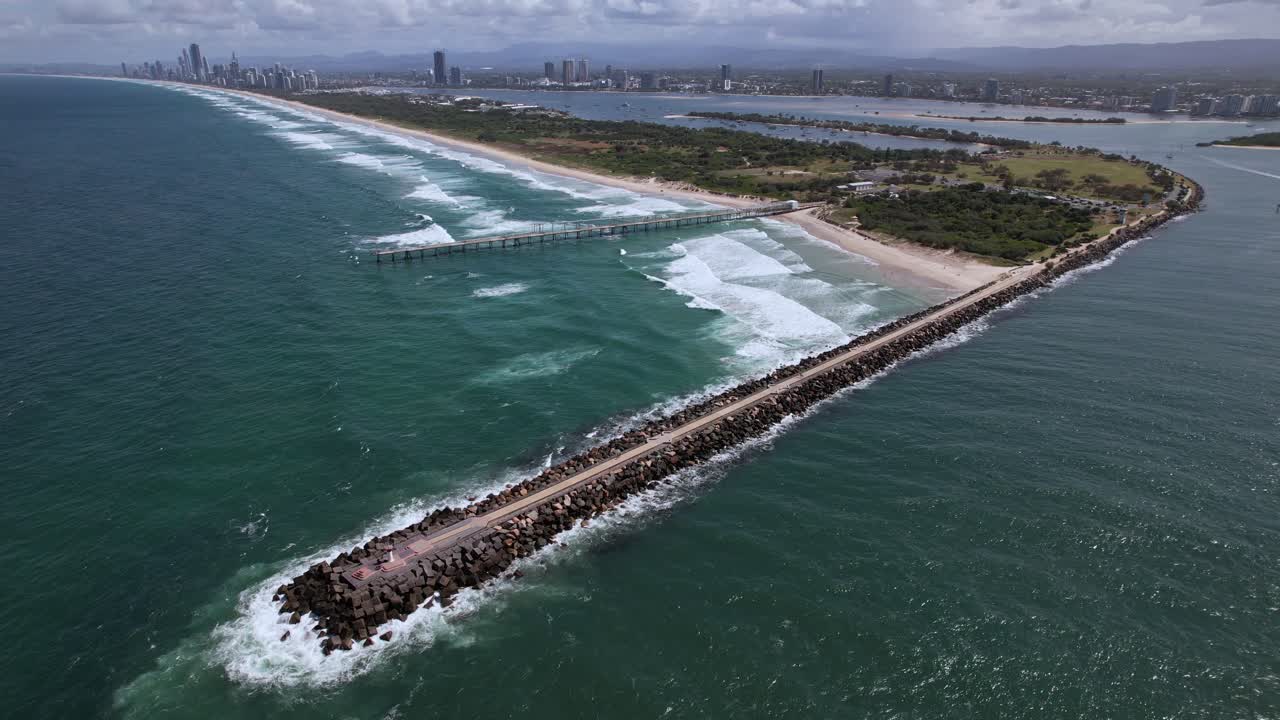 Aerial View Of The Spit Gold Coast - Rock Jetty And Sand Bypass System With City Skyline In Distance.