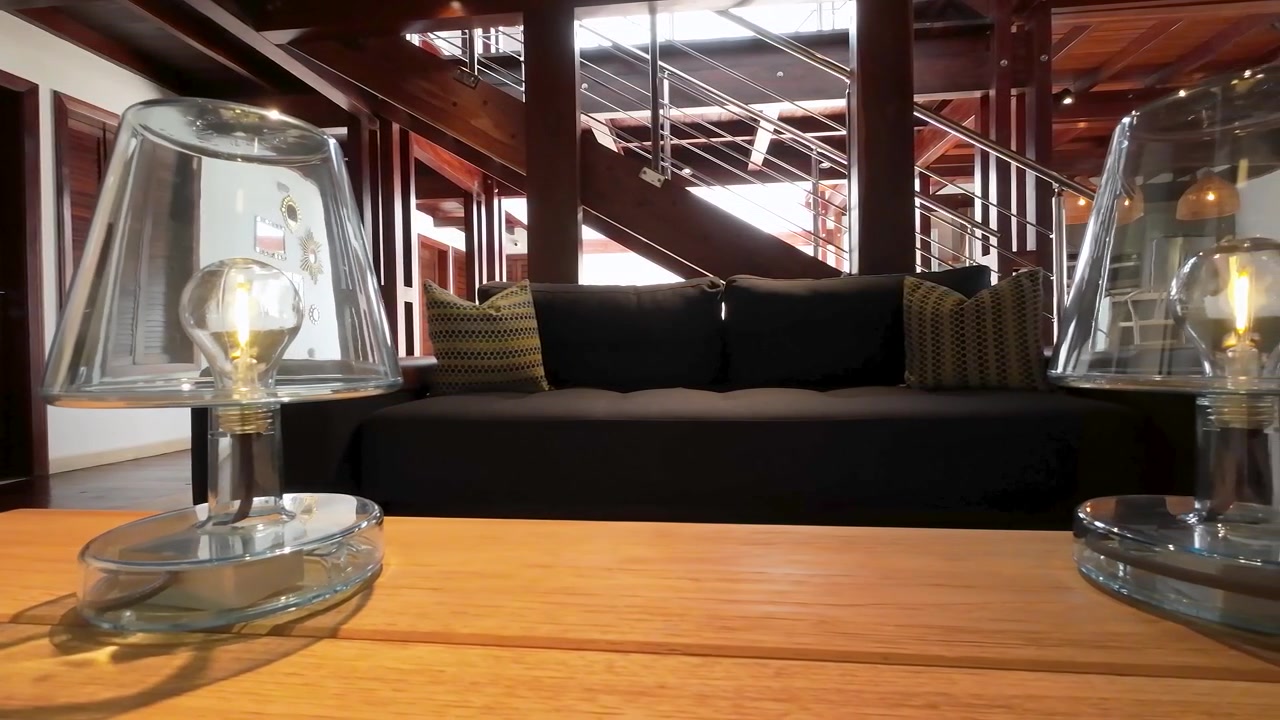 Luxury beach house with modern table lamps made of glass on wooden table, close up