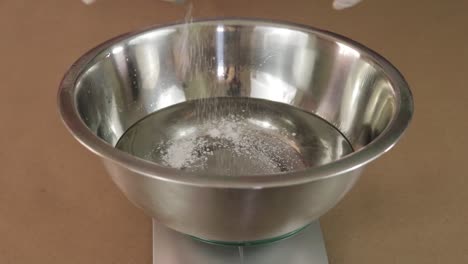 agregar polvo a un recipiente con ingredientes químicos
