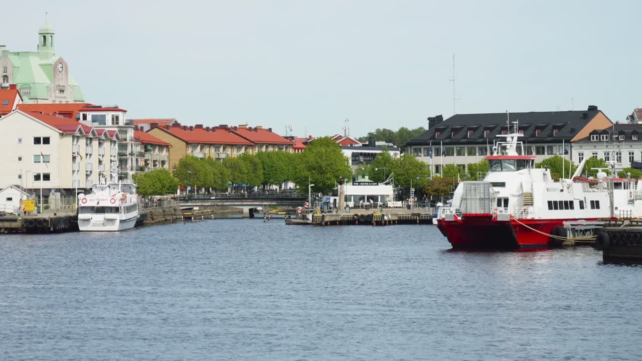Boats Docked On Harbor Of Stromstad With Town Hall In View. Vastra Gotaland, Sweden. wide shot, slow motion