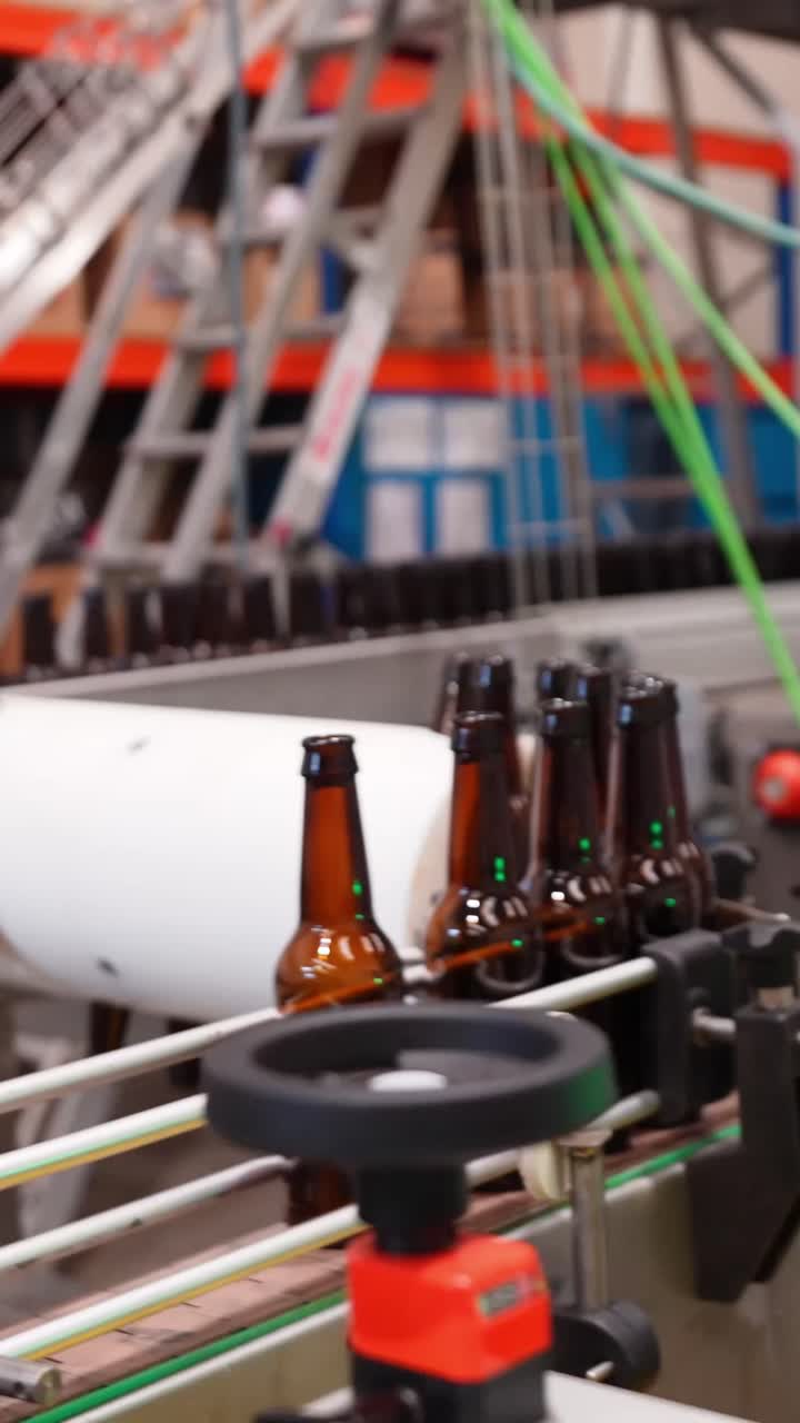 Botellas de cerveza en una cadena de producción en una fábrica