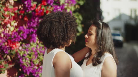 medium shot of lesbian couple hugging and kissing before wedding