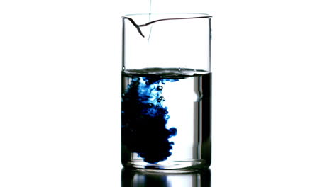 drops of blue liquid falling into beaker